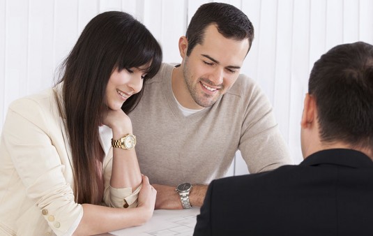Happy Young Couple Discussing with consultant